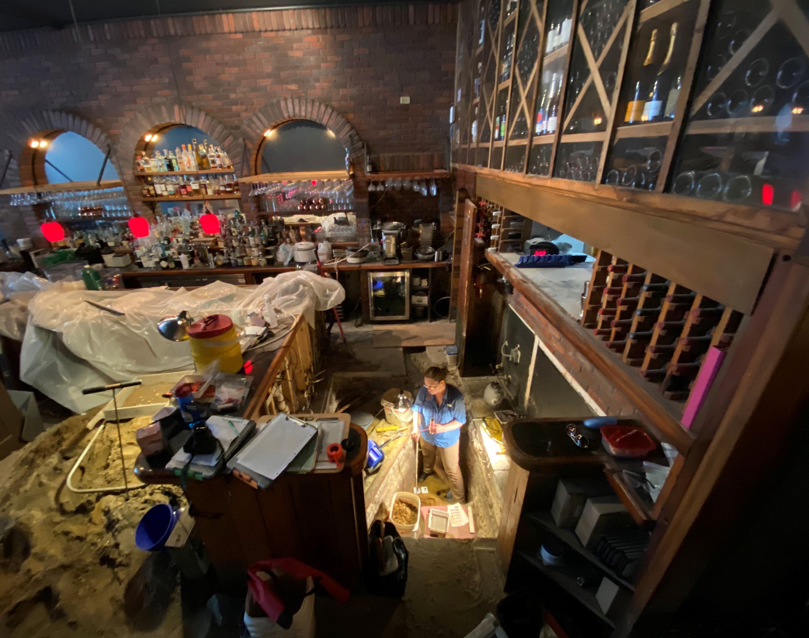 A woman works in an excavation area within a building