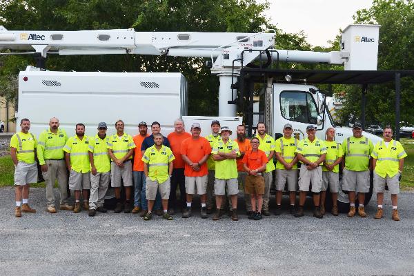 Streets and Grounds Crew standing in front of a city construction vehicle